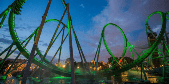 The Incredible Hulk Coaster glowing green at sunset.