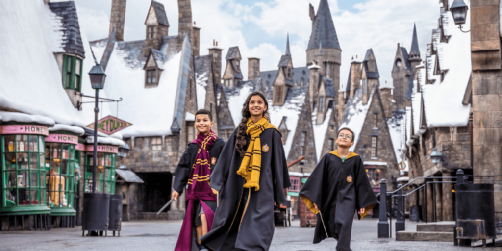 Three young guests visiting Hogsmeade at The Wizarding World of Harry Potter in Universal's Islands of Adventure at Universal Orlando Resort