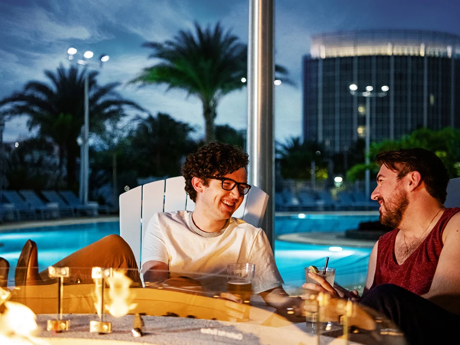 Universal Orlando Fall 2026 Guide: Events, Weather & Tips 7 Guests sitting beside an outdoor fire pit at Universal Aventura Hotel