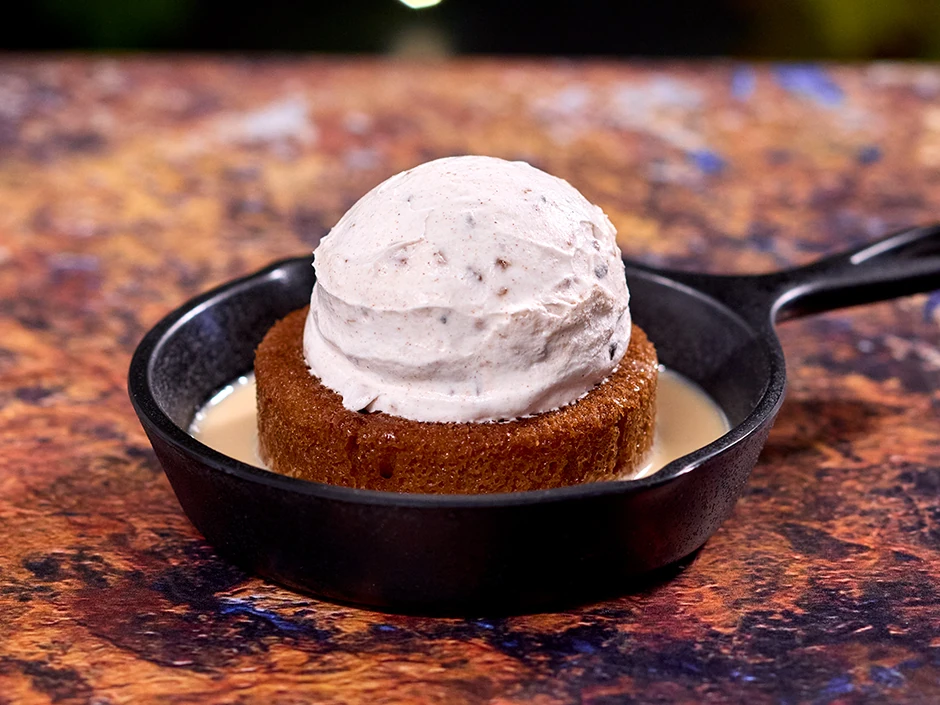 Best Things to Eat at Epic Universe 2026 (Food Guide) 18 Warm Sticky Cake with pecan-flavored ice cream at Oak & Star Tavern