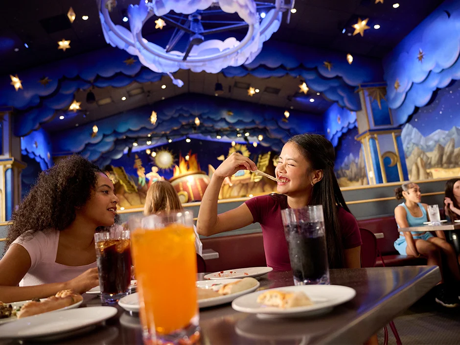 A Rainy Day Guide to Universal’s Epic Universe 7 Guests dining inside Pizza Moon in Celestial Park