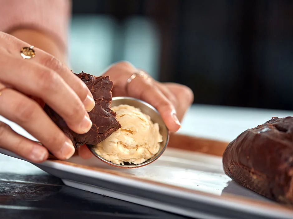 Universal Orlando Fall 2026 Guide: Events, Weather & Tips 15 Chocolate almond bread being dipped into salted caramel butter at Toothsome