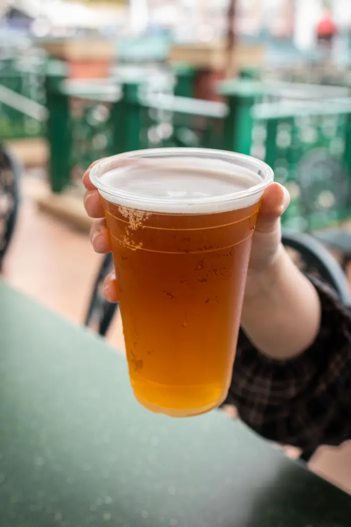 Dufftoberfest Brings Seasonal Duff Beer to Universal Studios Florida 1 A hand holds a cup of Dufftoberfest Beer at Duff Gardens in Springfield, U.S.A.