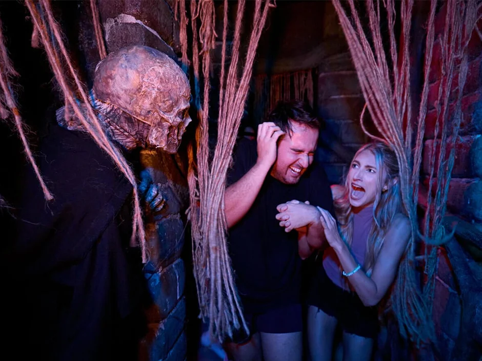 Halloween Horror Nights 2026 Tickets & Passes Guide 1 Guests reacting to a haunted house scare at Halloween Horror Nights