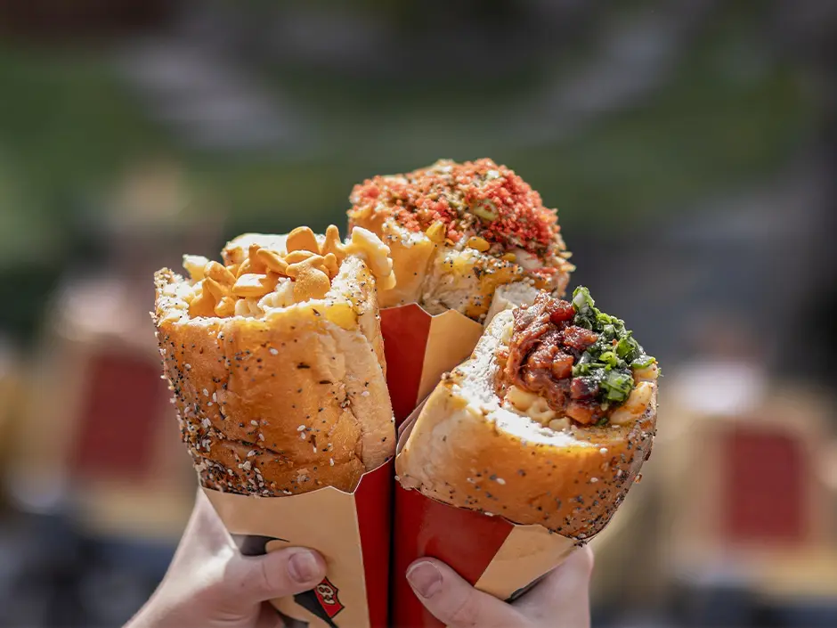 Universal Orlando's Bread Cone Craze Now Spans Two Parks 1 Guests holding mac and cheese bread cones in Isle of Berk