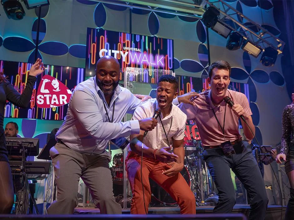 Universal Orlando Live Music: Dueling Pianos, Karaoke and Park Shows 1 Three guests singing into microphones on the Rising Star stage at Universal CityWalk