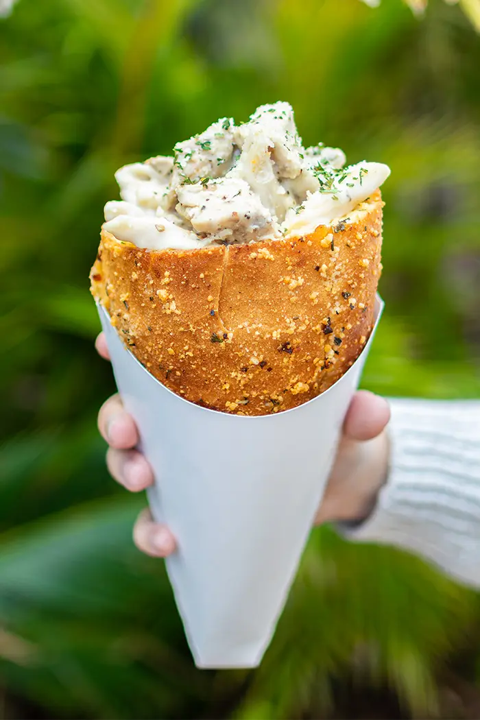 Universal Orlando's Bread Cone Craze Now Spans Two Parks 4 Hand holding a Chicken Alfredo Bread Cone in Jurassic Park