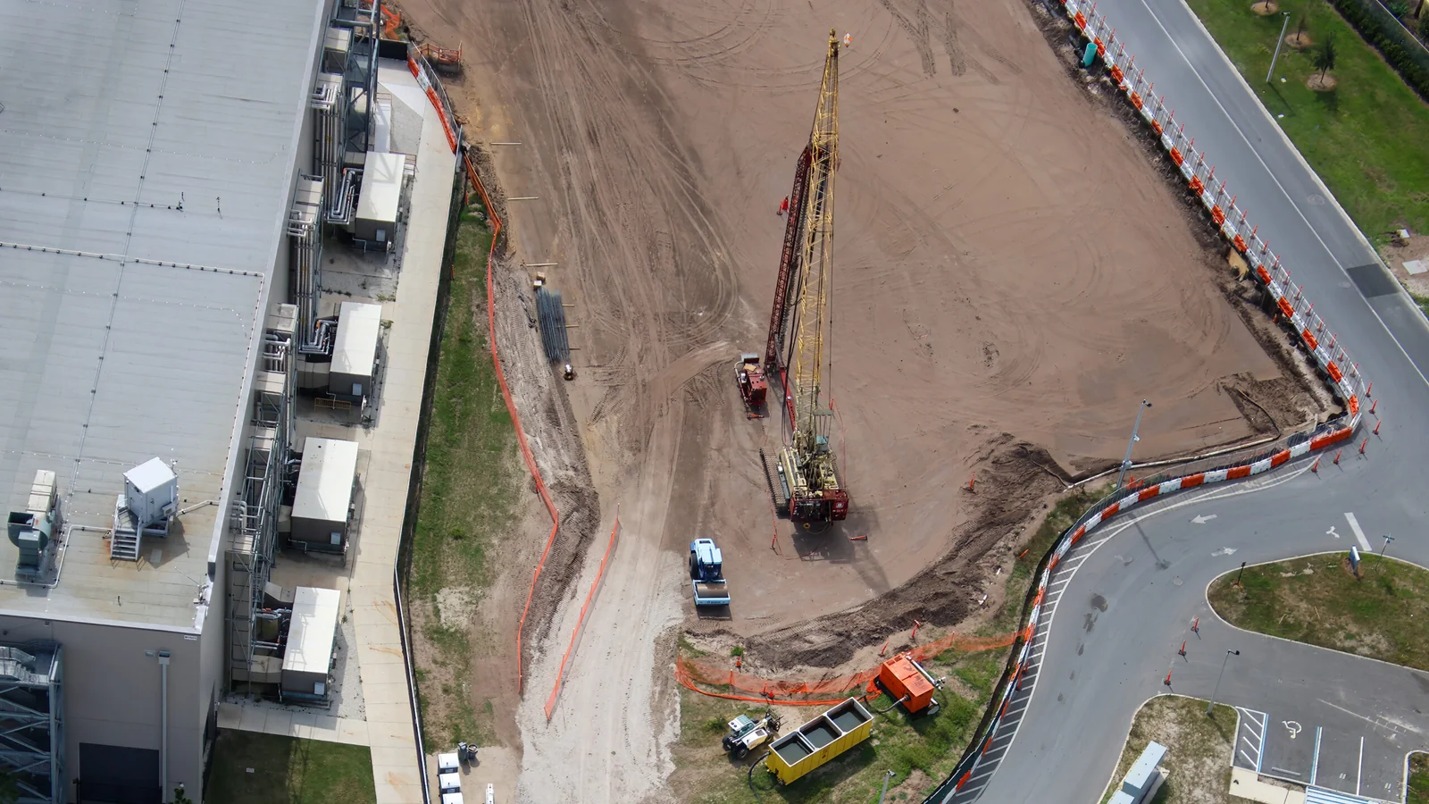 Foundation Work Advances Behind Dark Universe at Epic Universe 1 Large construction rig on the cleared site behind the Monsters Unchained building