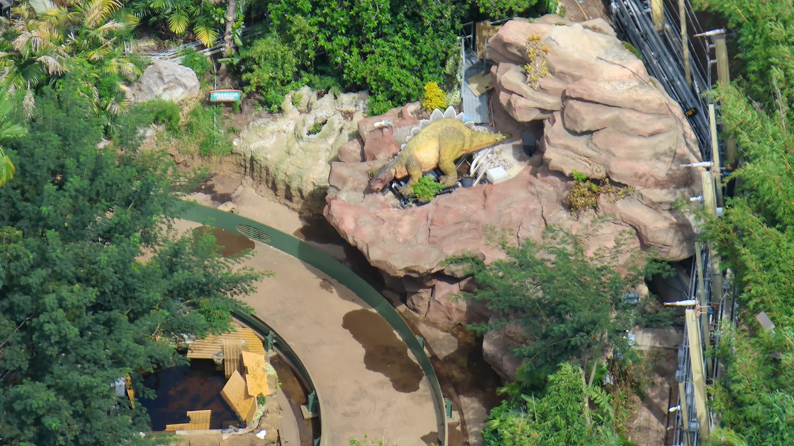 Jurassic Park River Adventure Photos Show Rebuilt Walls and Dinosaurs 2 Stegosaurus figure beside rocky scenery along the River Adventure channel