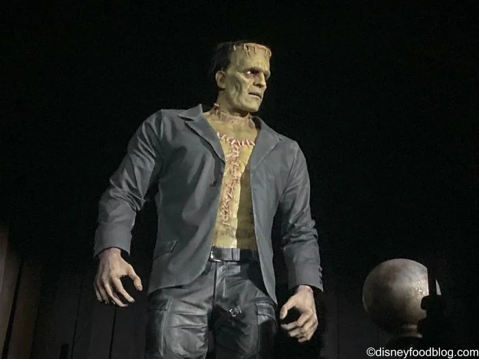 Epic Universe Crowds Ease, but Two Rides Still Need a Plan 2 Frankenstein's Monster wearing a dark jacket against a black background