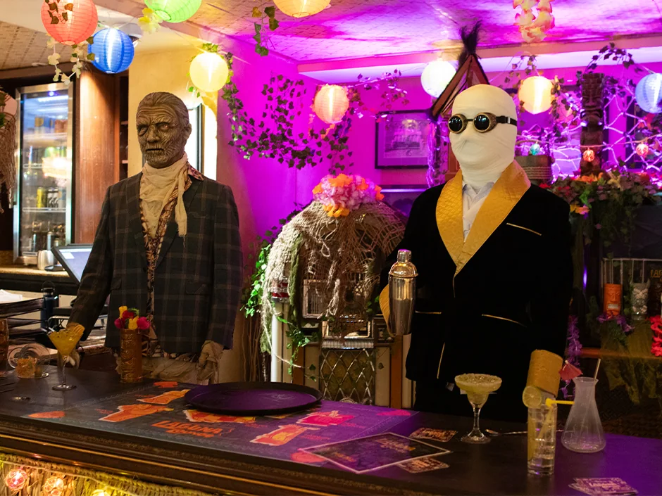 HHN 2026 Food, Shows and Merchandise: What to Prioritize 5 Mummy and Invisible Man mannequins behind a decorated bar