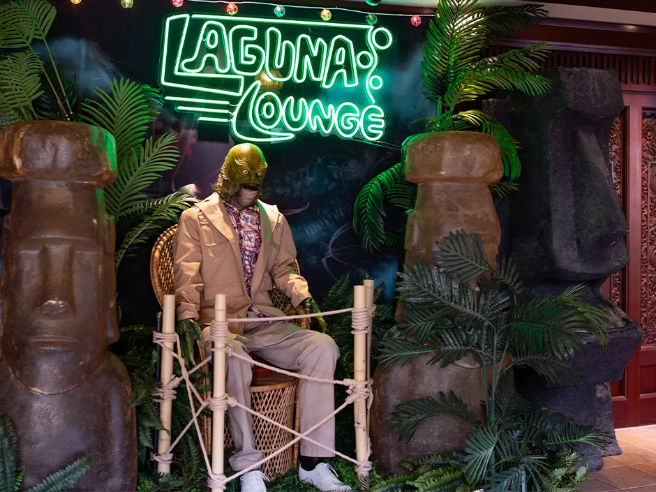 HHN 2026 Food, Shows and Merchandise: What to Prioritize 4 Gill-man mannequin seated beneath a Laguna Lounge neon sign